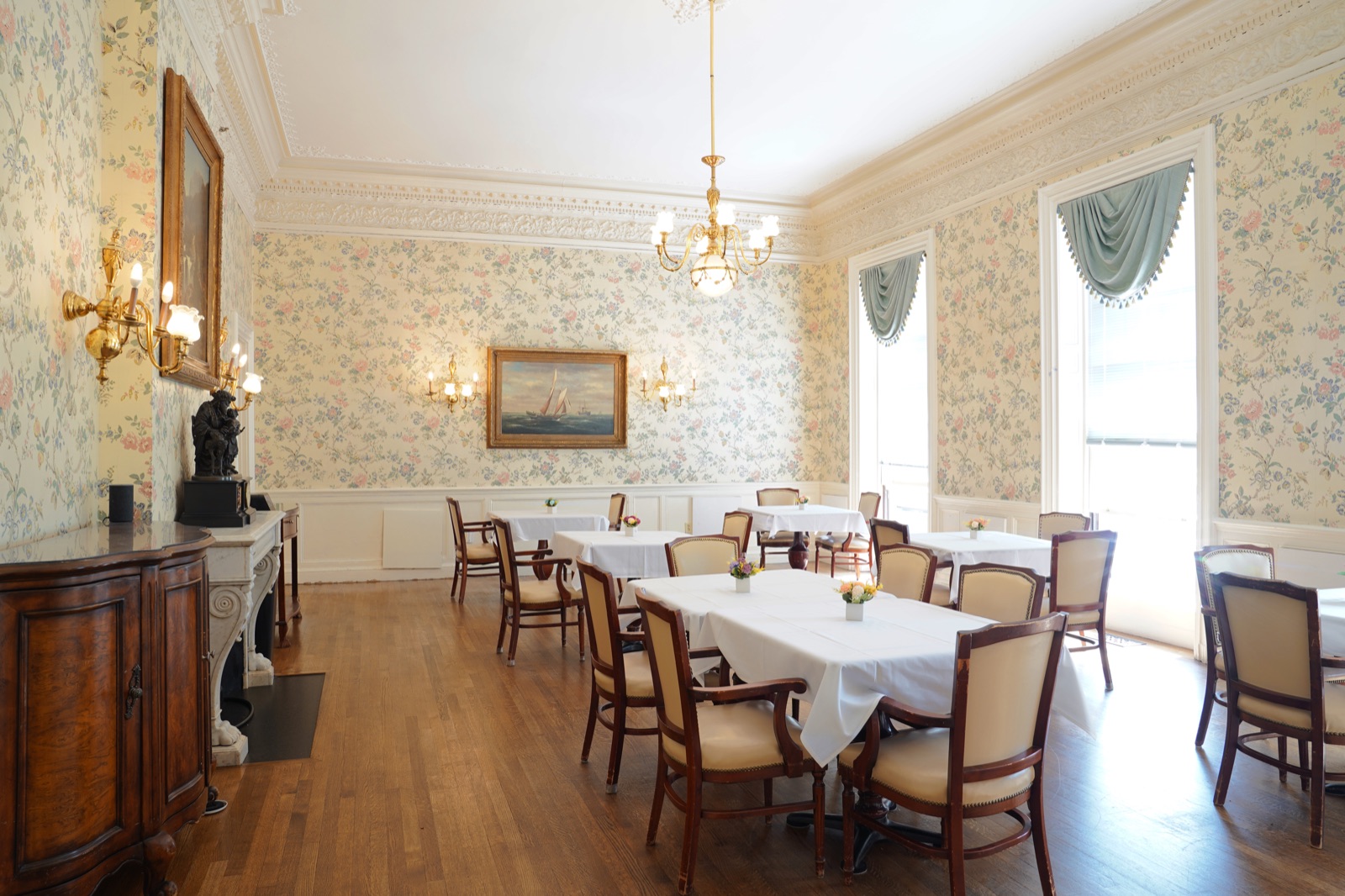 Elegant Salem dining room with floral wallpaper, chandelier, and fireplace