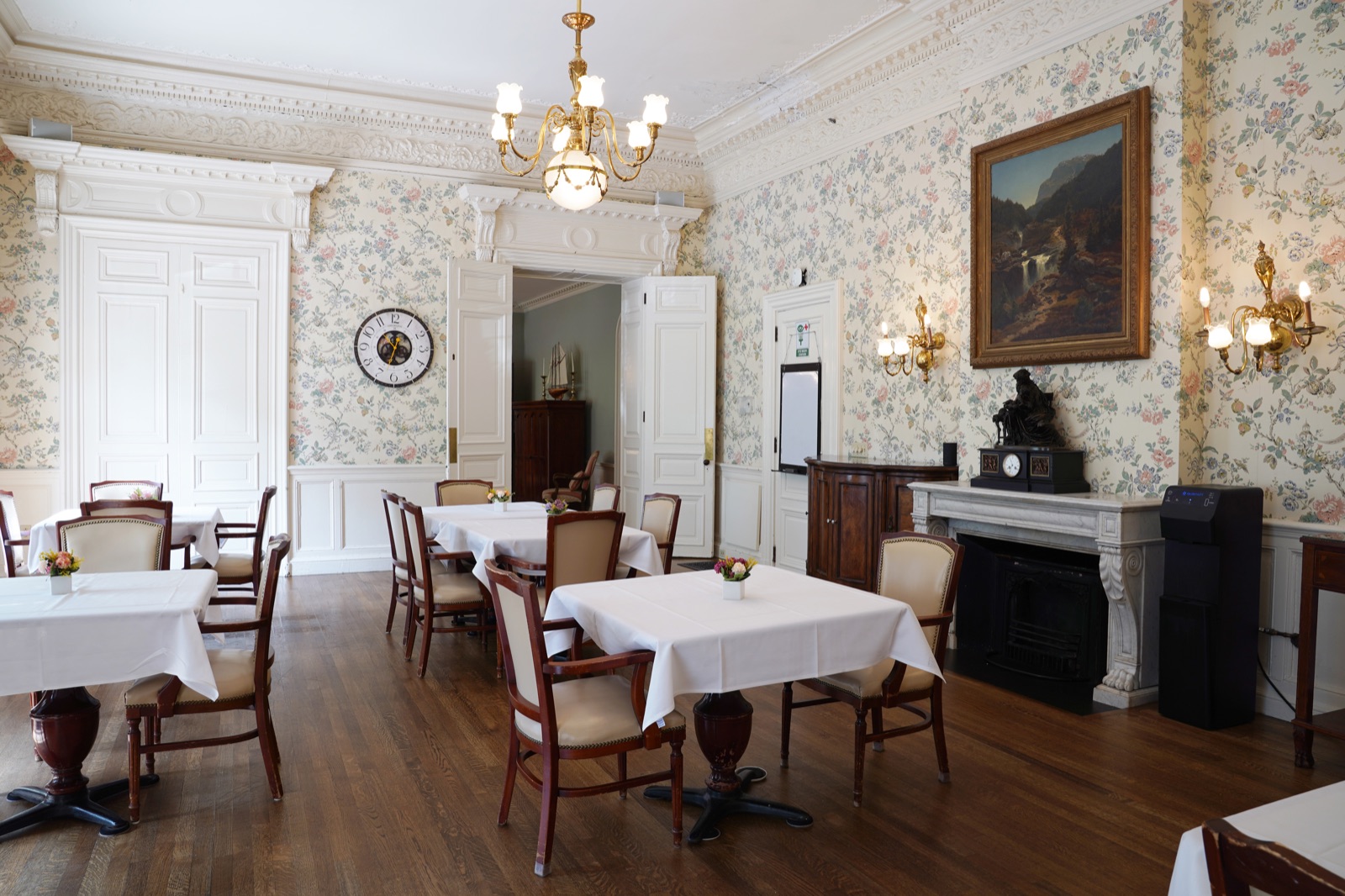 Historic dining hall with floral wallpaper and fireplace at John Bertram House of Salem