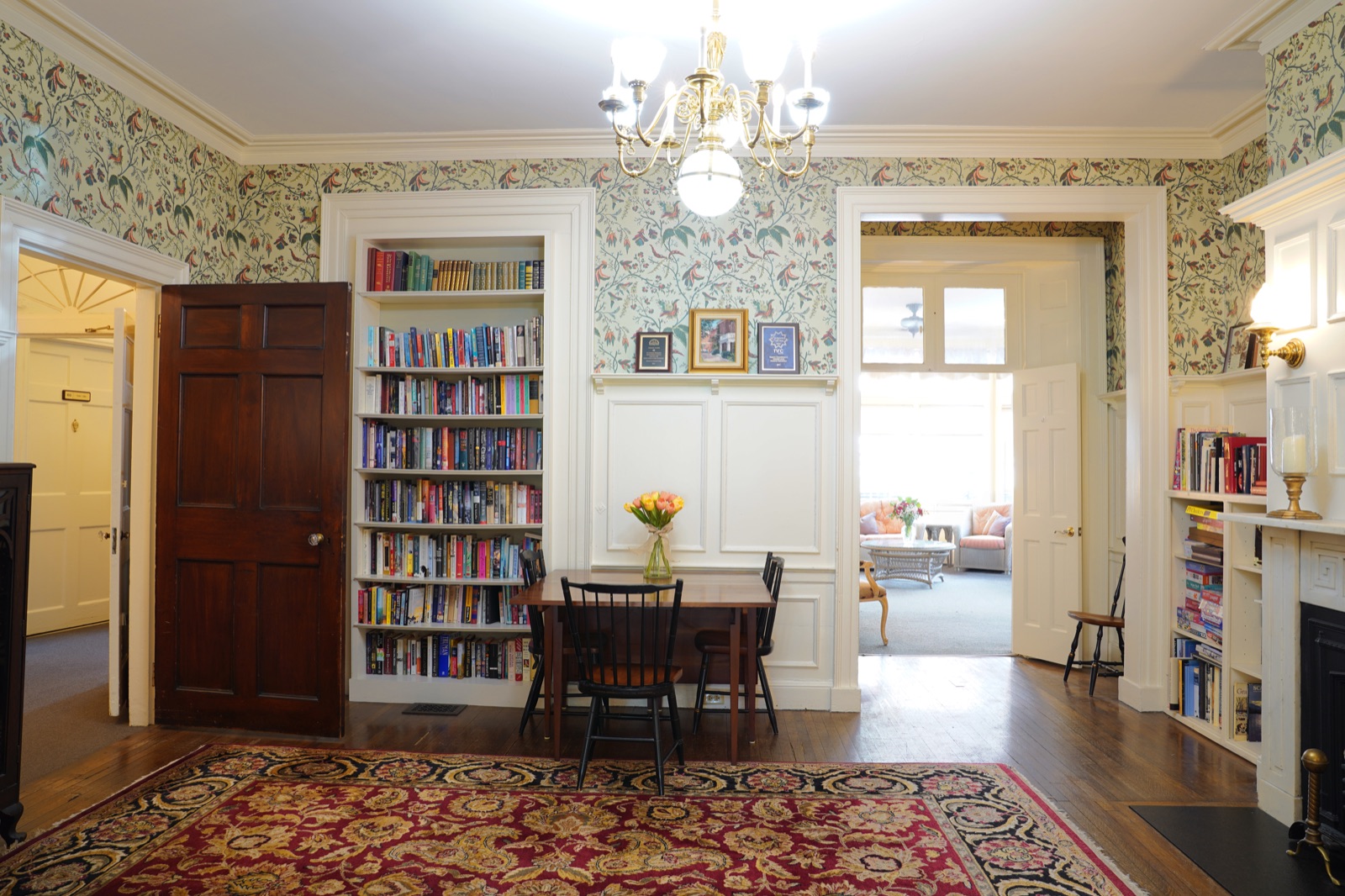 Reading room with built-in bookshelves and chandelier at John Bertram House of Salem