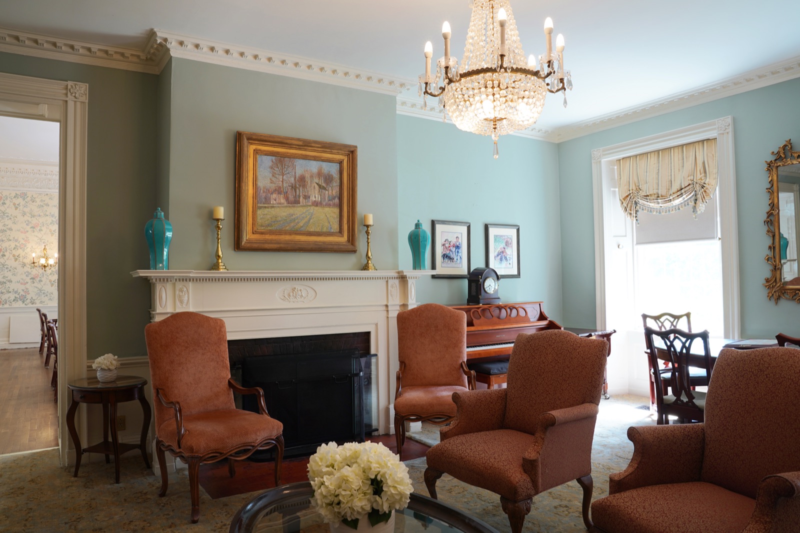 Elegant parlor with chandelier, fireplace, and piano at John Bertram House of Salem