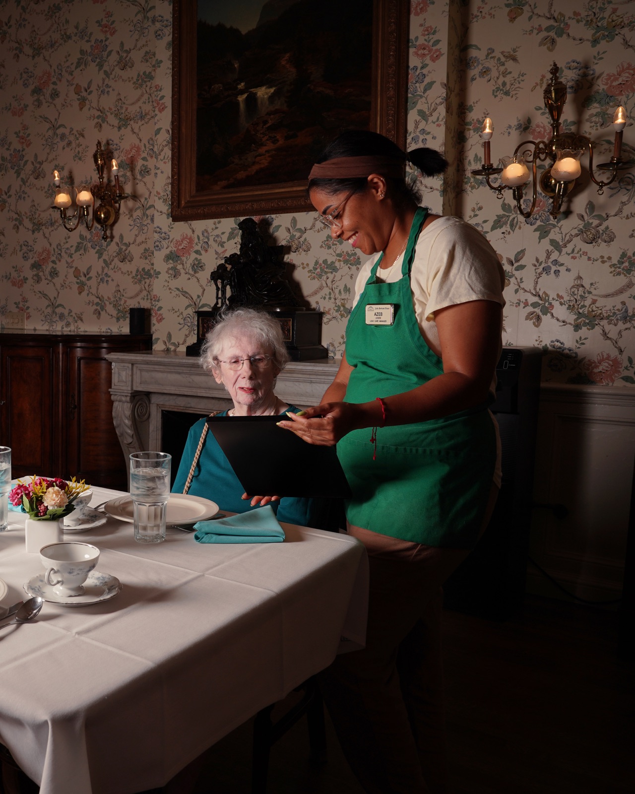 A server presenting the day’s menu to a resident in the elegant Salem dining room