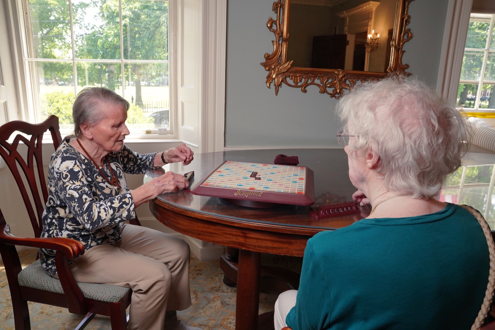 Two residents playing Scrabble at John Bertram House of Salem