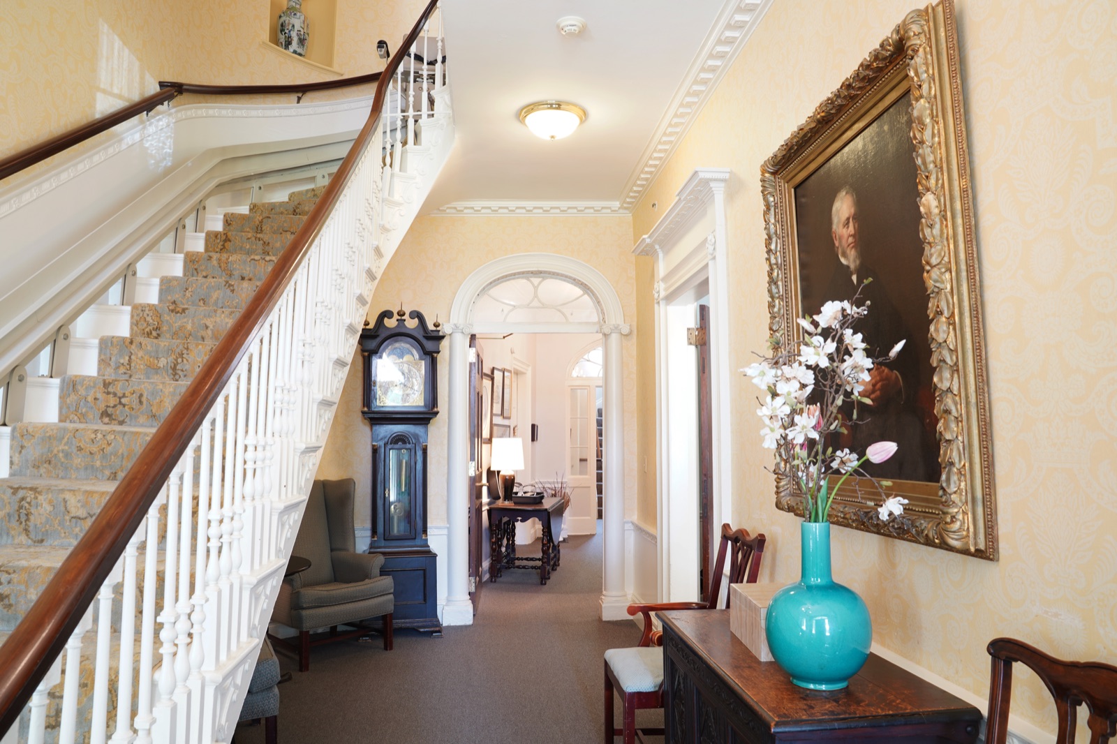 Grand staircase and front hall with grandfather clock at John Bertram House of Salem