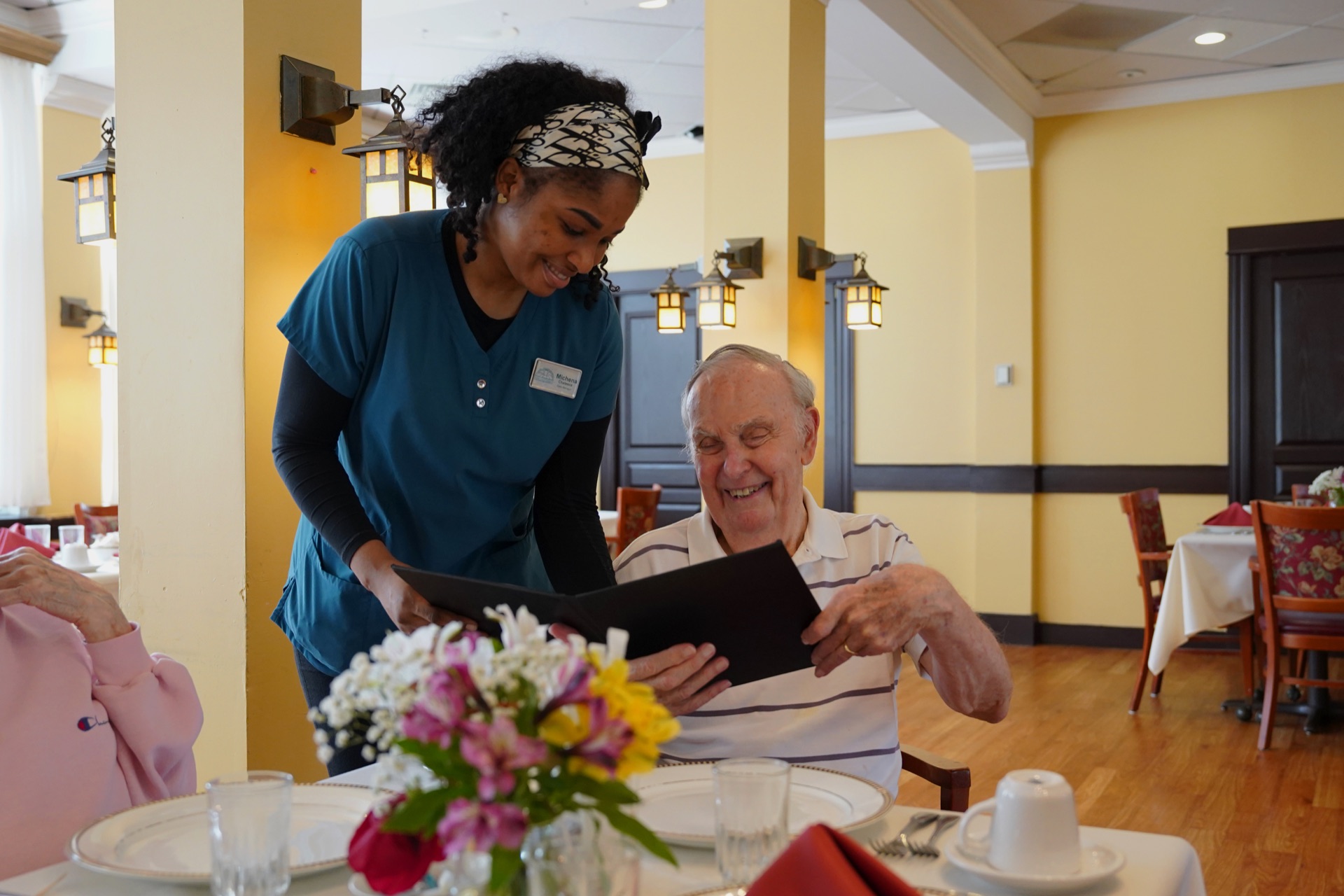 A caregiver sharing the menu with a resident at lunch